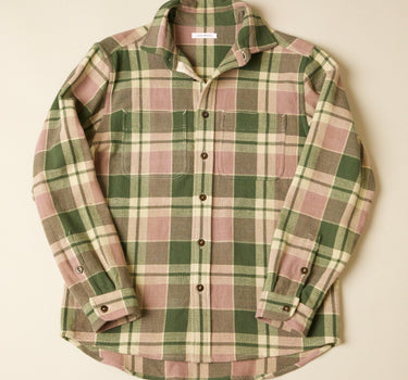 Green and pink plaid shirt on a beige background