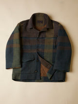 Plaid jacket with a mix of green, brown, and blue colors on a beige background