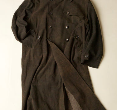 Dark coat with button details on a light beige background