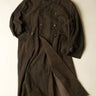 Dark coat with button details on a light beige background