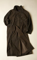Dark coat with button details on a light beige background