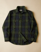 Green and black and navy plaid shirt on a beige background