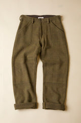 Pair of olive green pants on a beige background