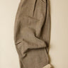 Folded gray pleated pants on a beige background