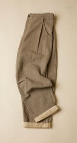 Folded gray pleated pants on a beige background
