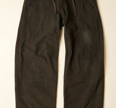 Dark brown pants on a beige background