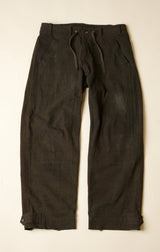Dark brown pants on a beige background