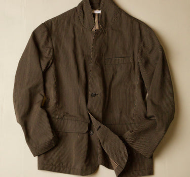 Black and brown jacket with a subtle  stripe pattern on a beige background