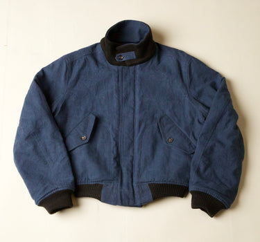 Blue jacket with black trim on a beige background