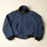 Blue jacket with black trim on a beige background