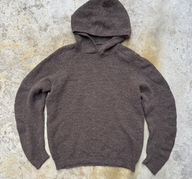 Brown hoodie on a textured gray surface