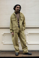 A man wearing a matching khaki olive green utility jacket and trousers set.
