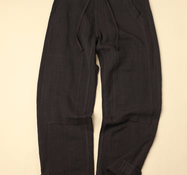 Pair of dark gray pants on a beige background