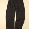 Pair of dark gray pants on a beige background
