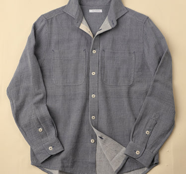 light blue gray button-up shirt with a beige background