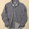 light blue gray button-up shirt with a beige background