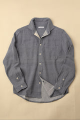light blue gray button-up shirt with a beige background
