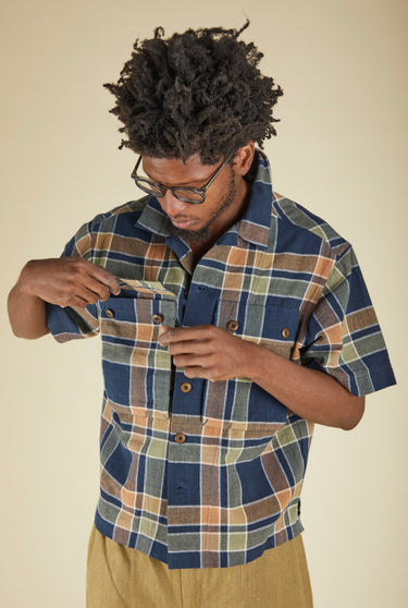 Man wearing a plaid shirt against a beige background