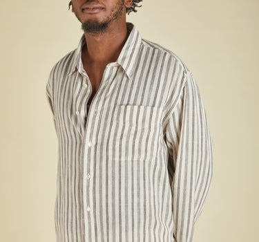 Man wearing a striped shirt against a beige background
