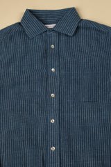 Blue striped shirt with collar and buttons on a beige background