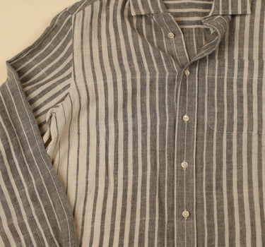 Gray and natural striped shirt with a beige background