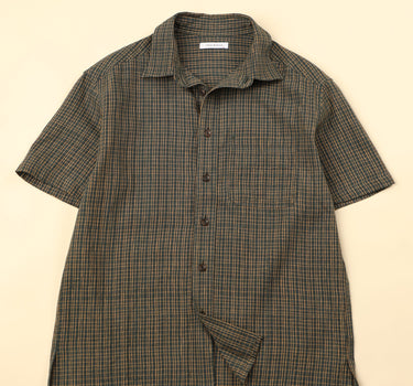 Flat green checkered shirt on a beige background