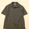 Flat green checkered shirt on a beige background