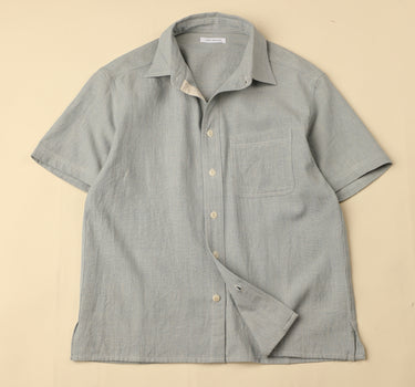 Flat light blue shirt on a beige background