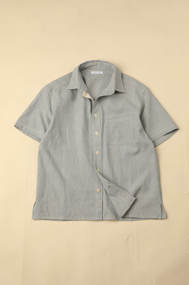 Flat light blue shirt on a beige background