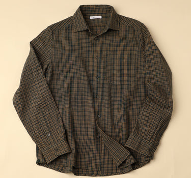 Flat long sleeved green and brown checkered shirt on a beige background