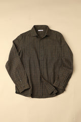 Flat long sleeved green and brown checkered shirt on a beige background