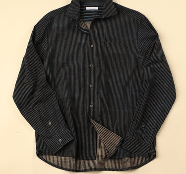Flat black and blue striped shirt on a beige background