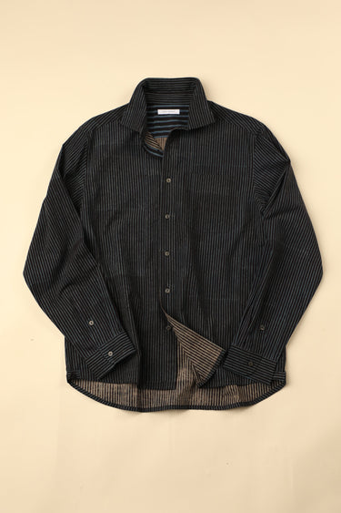 Flat black and blue striped shirt on a beige background