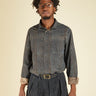 Man wearing a striped shirt and pants with a belt on a beige background