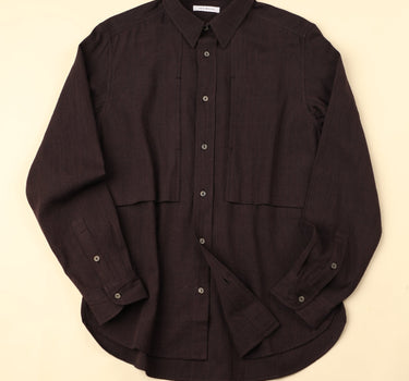 Flat dark plum shirt on a beige background