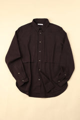 Flat dark plum shirt on a beige background