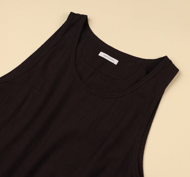 Plum sleeveless top with a brand label on a beige background