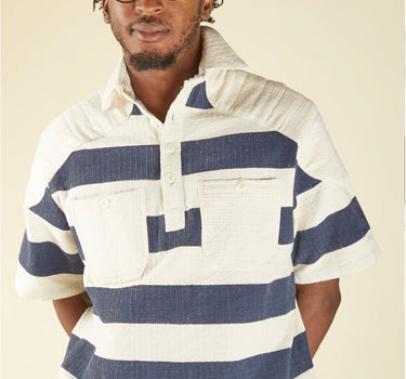 Man wearing a blue and white striped shirt against a beige background