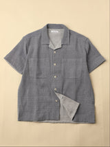 Light blue gray short-sleeve shirt with button details on a beige background