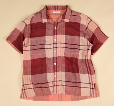 Plaid shirt with red and pink pattern on a beige background