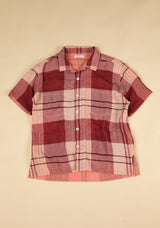 Plaid shirt with red and pink pattern on a beige background