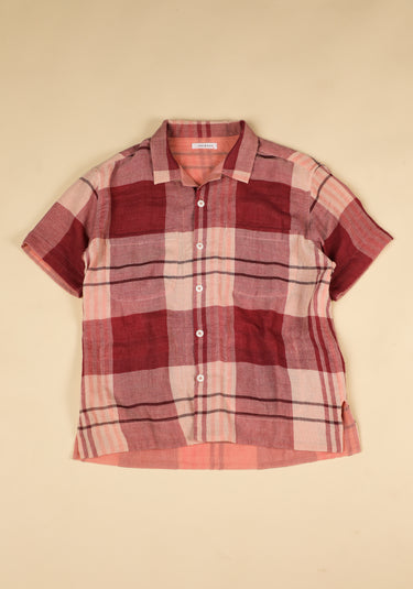 Plaid shirt with red and pink pattern on a beige background