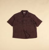 plum short-sleeve shirt with multiple pockets on a beige background