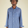 Man wearing a blue checkered shirt against a beige background