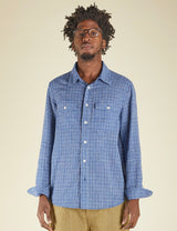 Man wearing a blue checkered shirt against a beige background