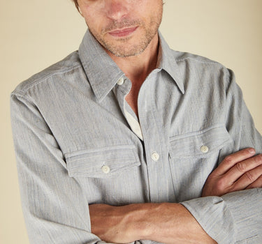 Man wearing a light blue shirt with a neutral background