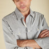Man wearing a light blue shirt with a neutral background