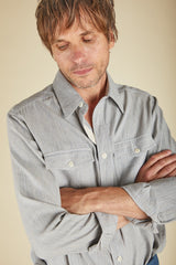 Man wearing a light blue shirt with a neutral background