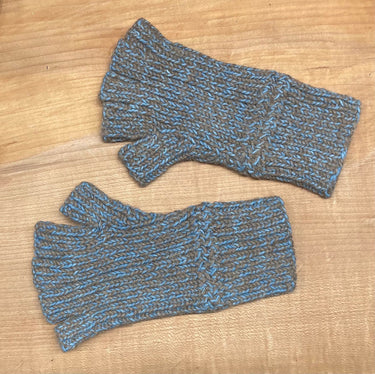 Pair of blue and brown fingerless gloves on a wooden surface